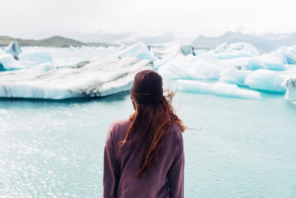 back of woman looking at icebergs