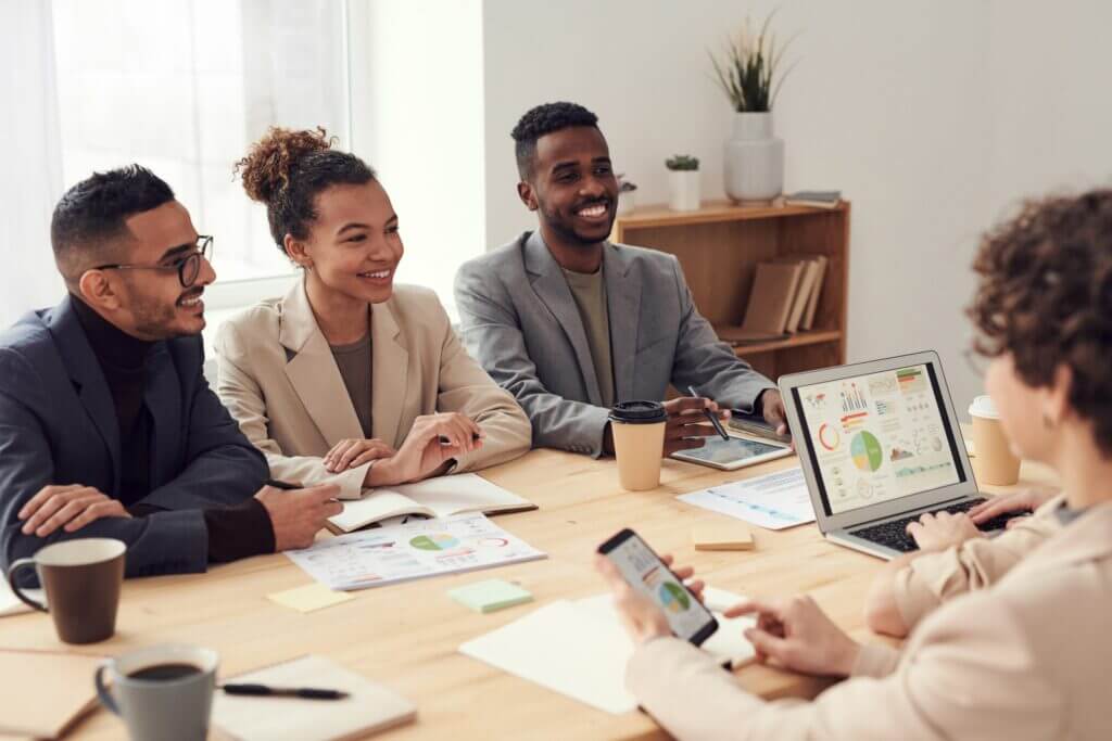 Group photo of diverse professionals around a conference table.