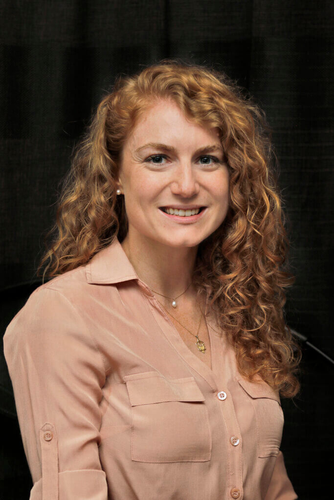 A smiling woman with curly red hair