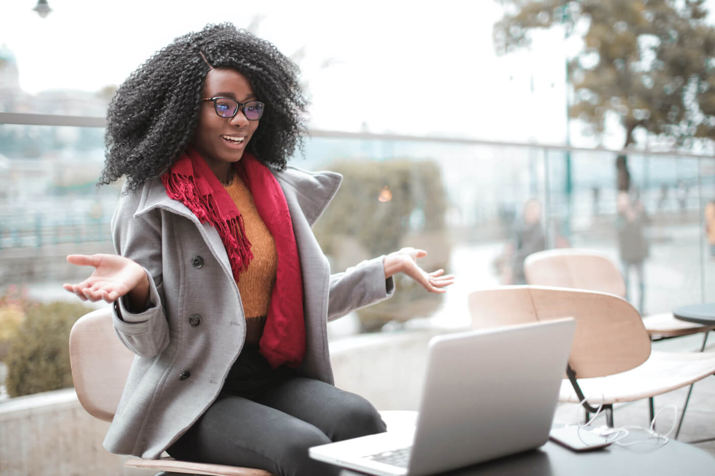 A young professional gestures at her laptop during a virtual meeting